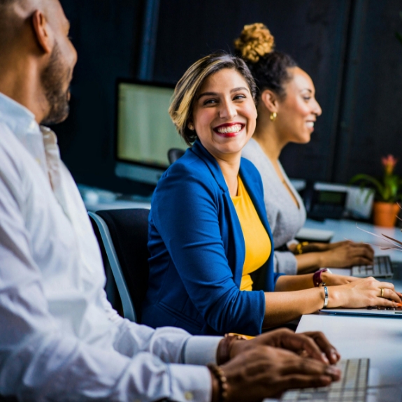 Woman in an office smiling at a man sitting next to her