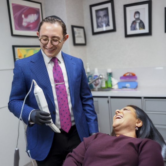 Doctor Ariel smiling at a woman in the dental chair