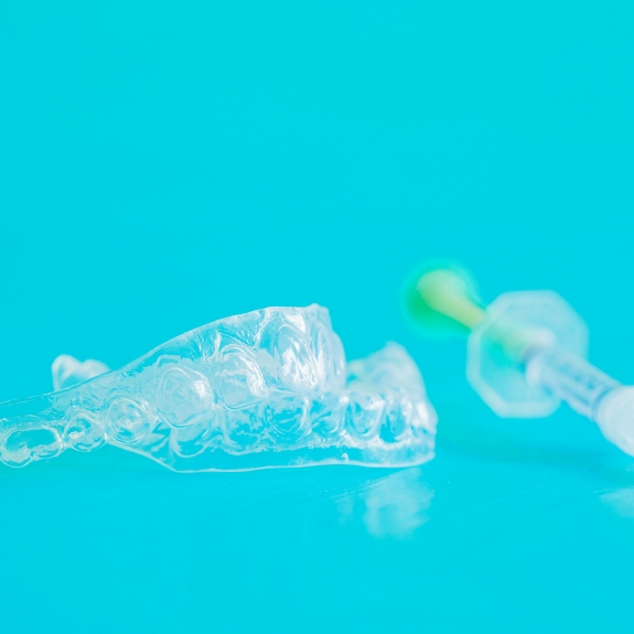 Two clear teeth whitening trays and an applicator