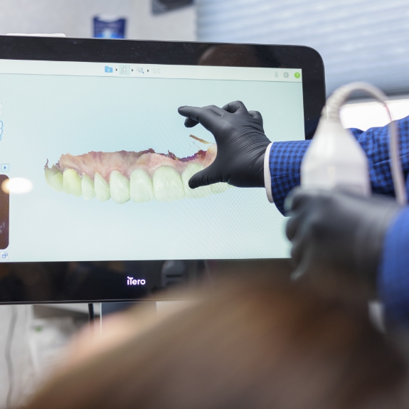 Dentist touching a monitor showing a digital impression of a patients teeth