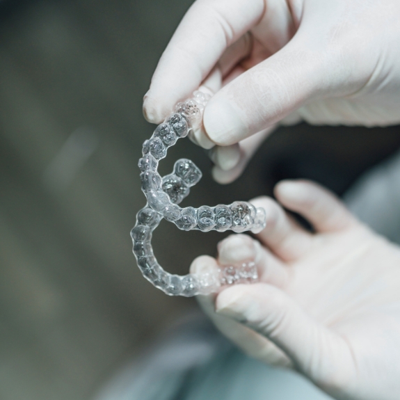 Dentist holding two Invisalign clear aligners