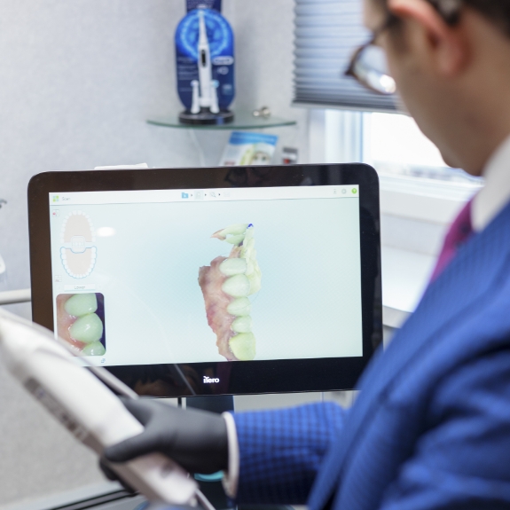 Doctor Ariel looking at digital scans of a patient's teeth