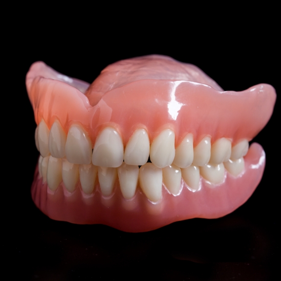 Set of full dentures against a black background