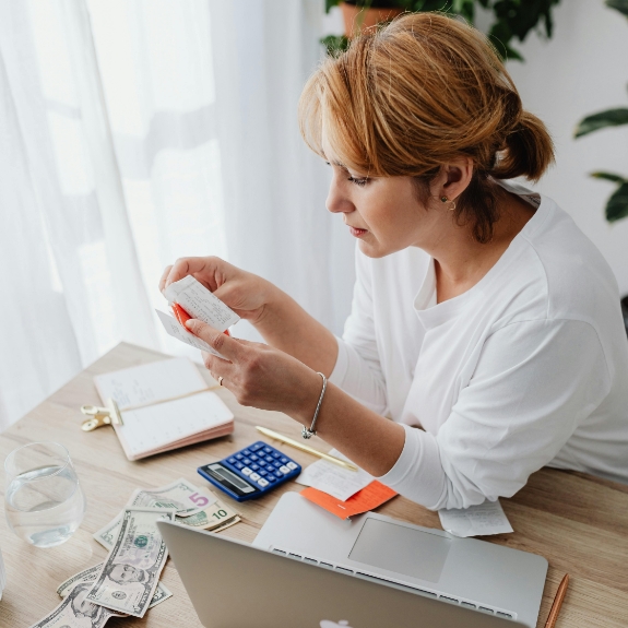 Woman looking at receipts while calculating costs