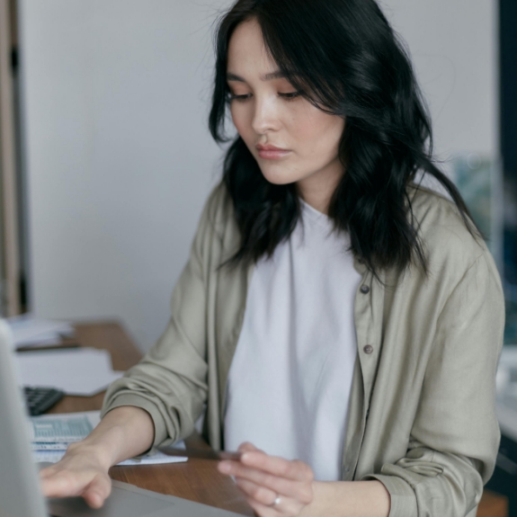 Young woman sitting at a table using her laptop