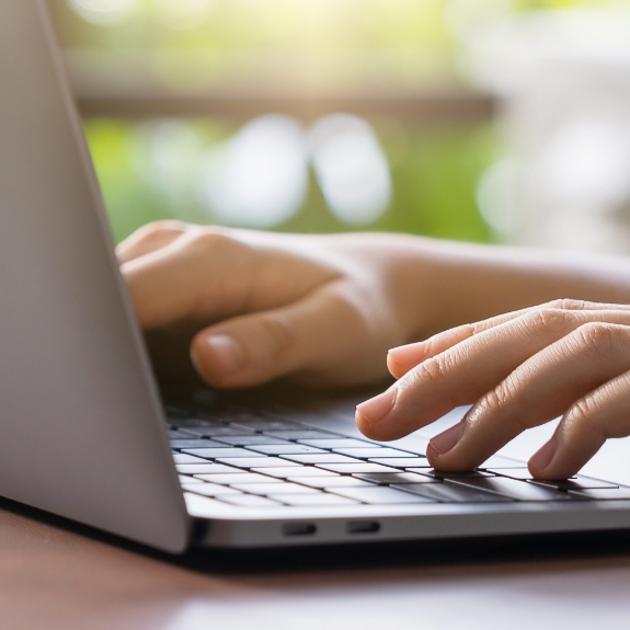Close up of hands typing on a laptop