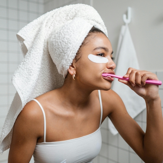 Woman brushing her teeth at home