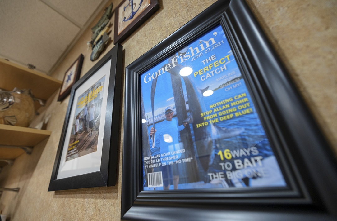 Doctor Mohr holding a huge fish on a boat on a framed cover of Gone Fishin Magazine on the wall