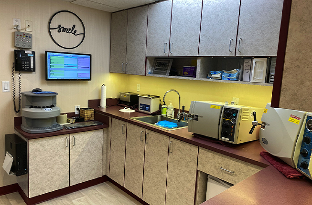 Room with storage cabinets and various dental technology devices on the countertops