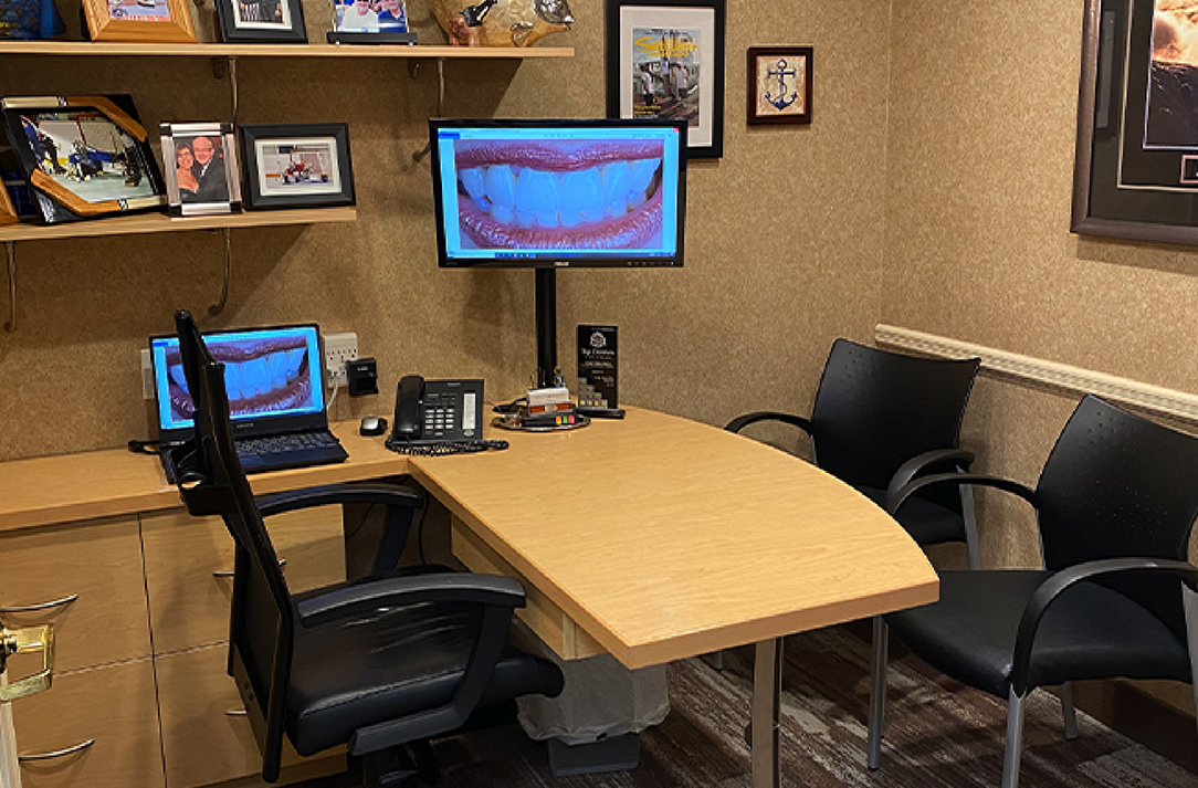 Consultation room with a close up photo of a smile on two computer monitors