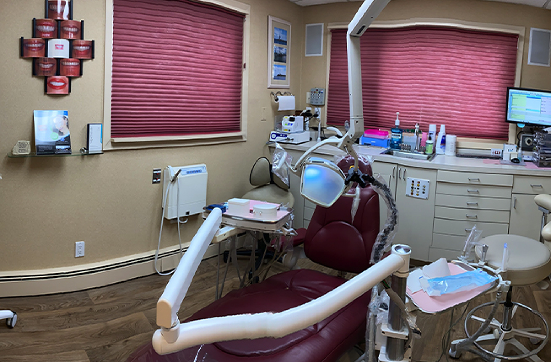 Dental exam room with red blinds drawn