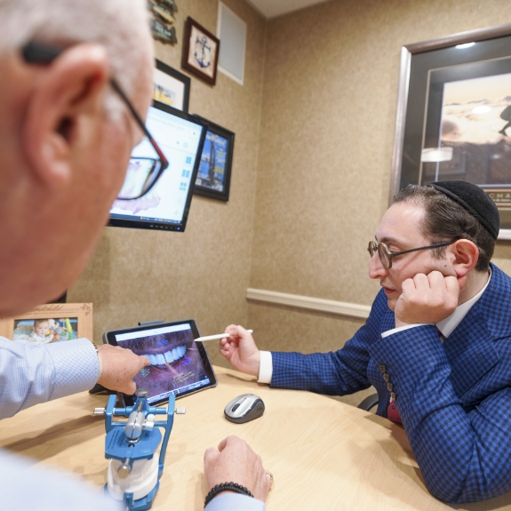 Doctor Mohr and Doctor Ariel discussing a photo of a patient's teeth