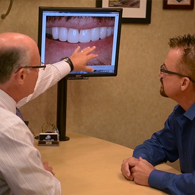 Dentist showing patient smile images
