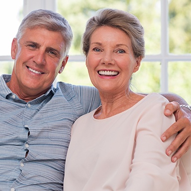 Older couple smiling after receiving the best dental implants on Long Island