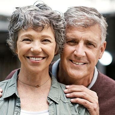 Older Long Island couple smiling with perfect dentures