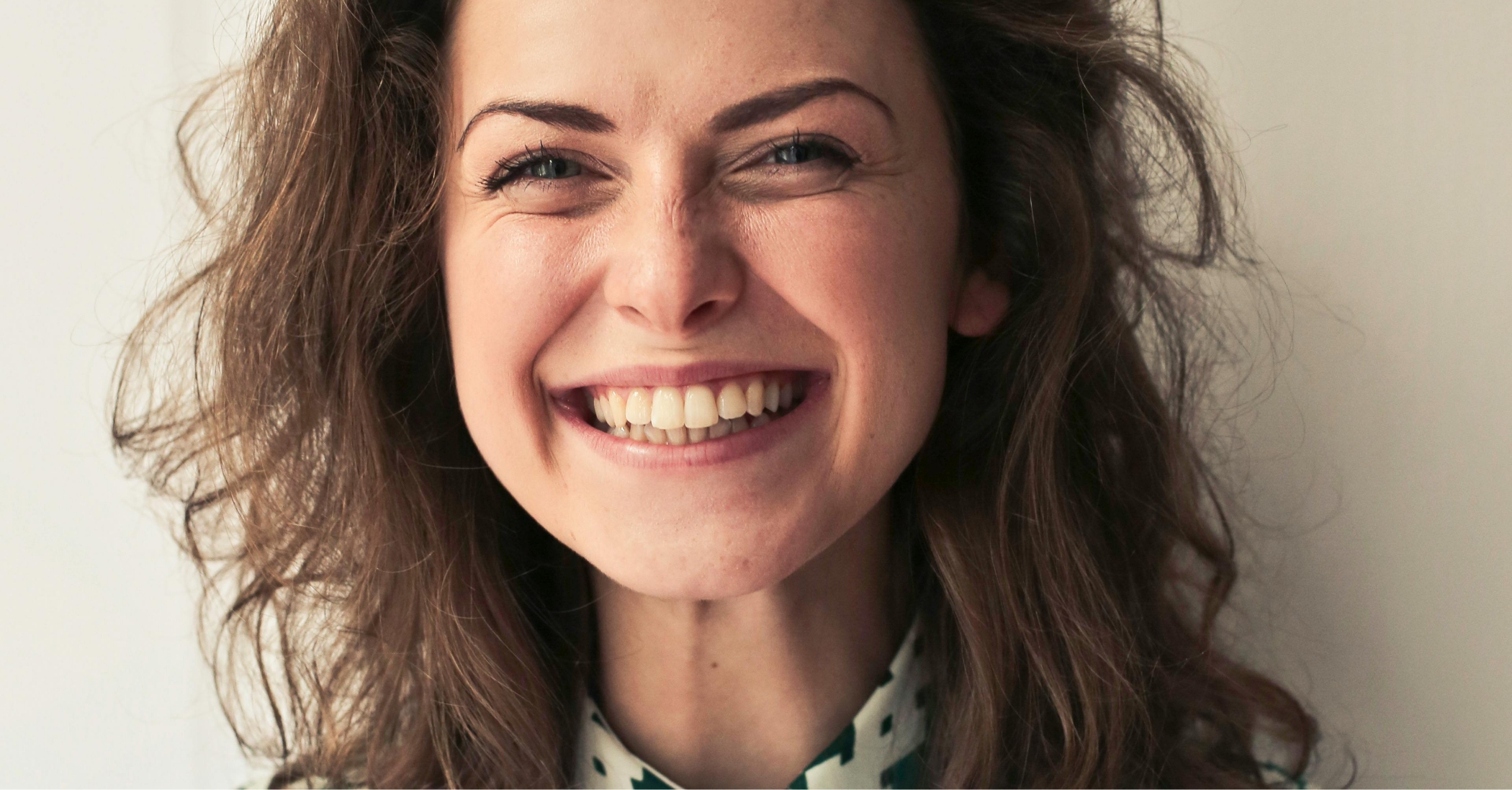 Brunette woman grinning after gummy smile correction in Massapequa Park