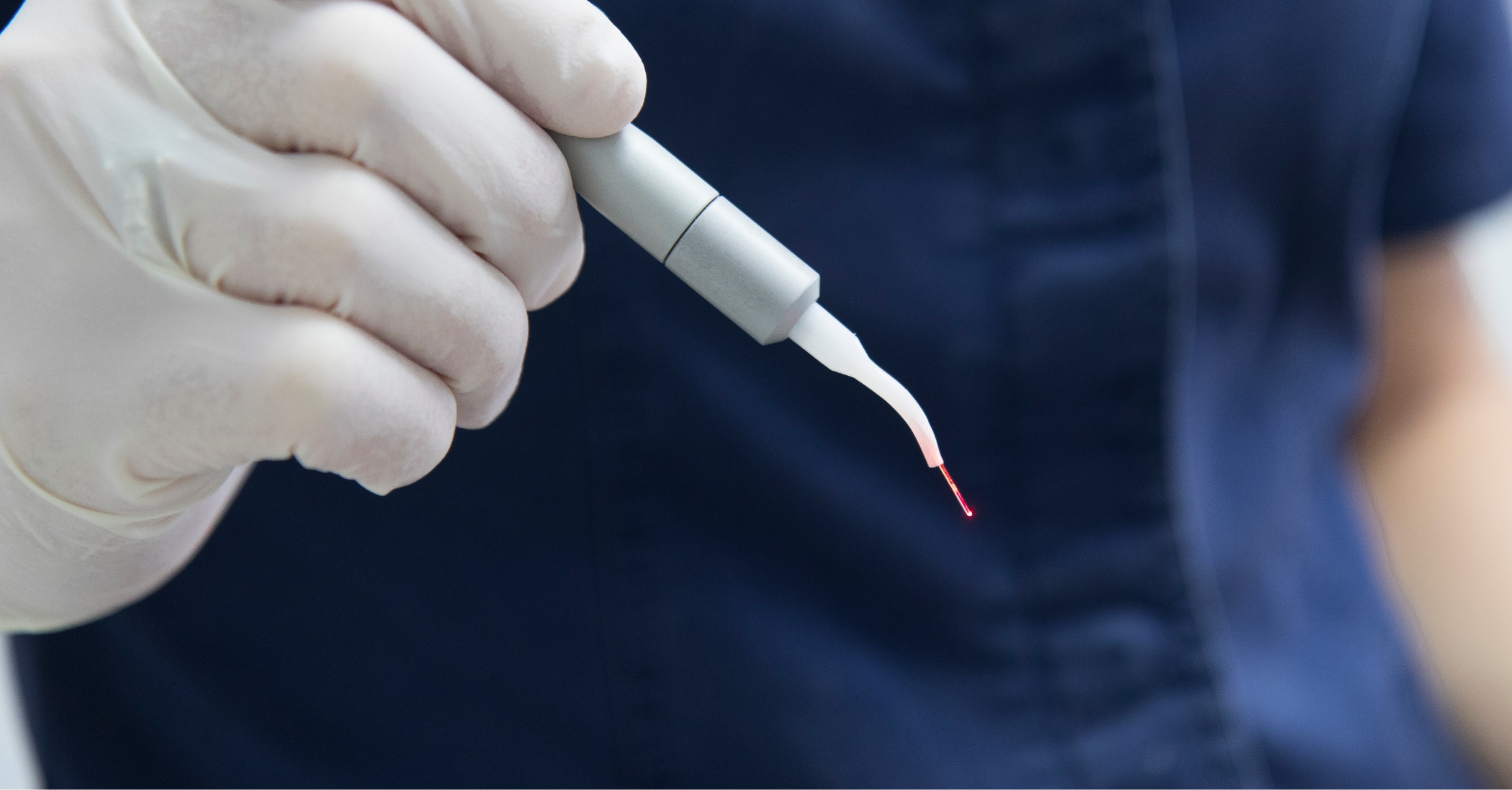 Dentist holding a pen like dental laser device