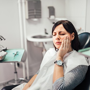 Woman sitting in dental office with hurting tooth 