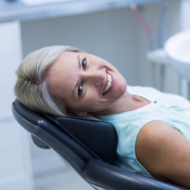 Smiling Long Island dental patient in a dental chair