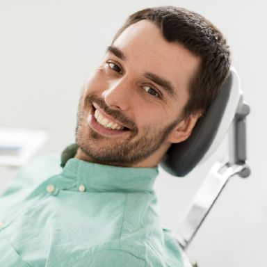 Happy Massapequa Park dental patient in a dental chair