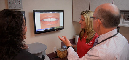 Dentist and patient looking at smile design photos