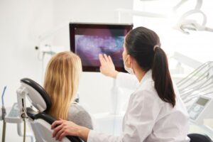 dental assistant going over X-ray with patient 