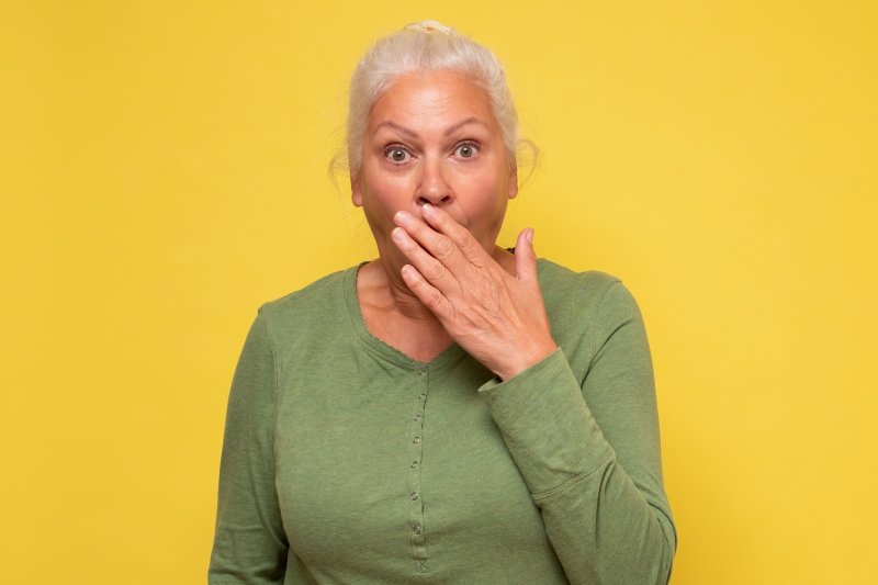 older woman covering mouth 