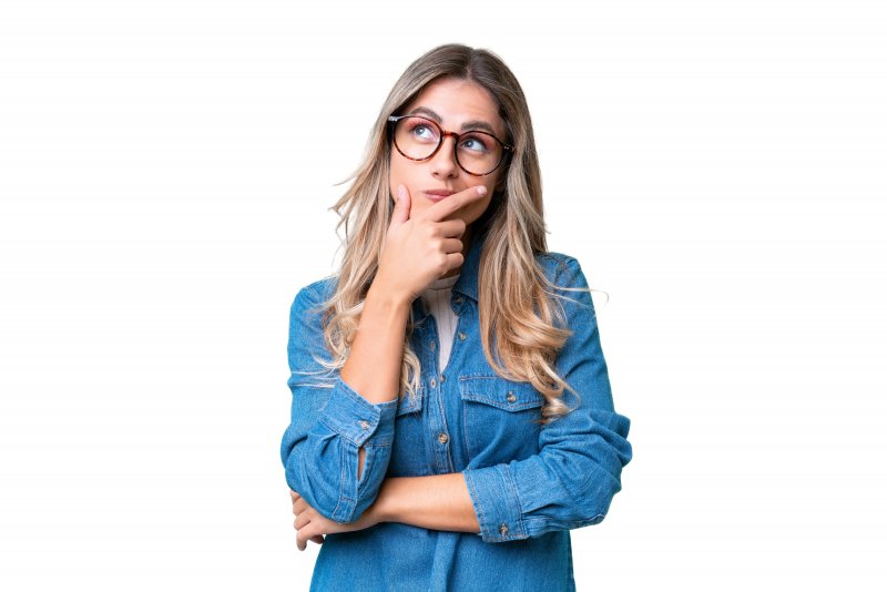 woman pondering about cosmetic dentistry 